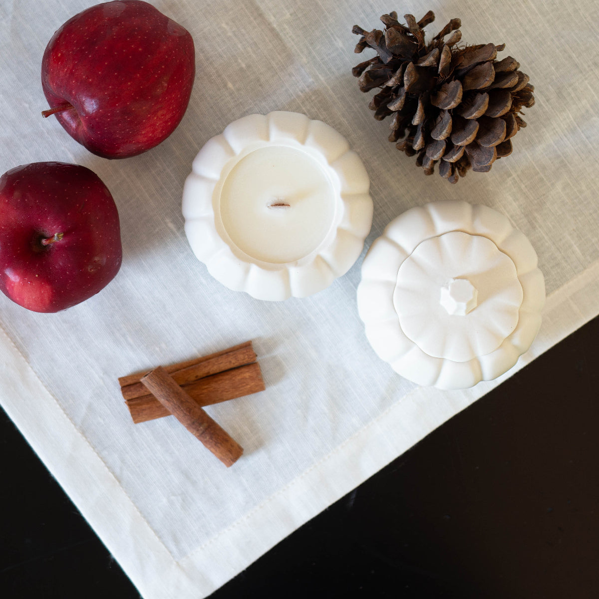 Bougie de soya parfumée à la pomme et aux épices dans un pot en jesmonite.