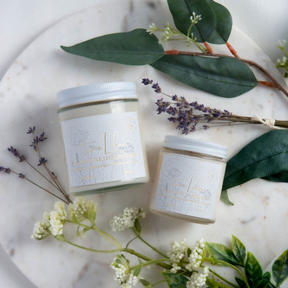 Diffuser une ambiance printanière avec une bougie parfumée en cire de soya biologique aux notes de lilas mauve et d'iris, offerte avec mèche de bois ou coton.