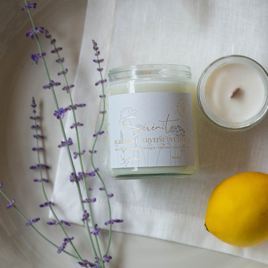 Diffuser une ambiance fraîche avec une bougie parfumée en cire de soya biologique aux notes de verveine et citron, offerte avec mèche de bois ou coton.