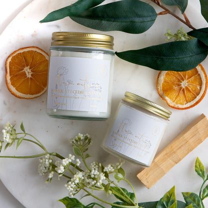 Diffuser une ambiance rafraîchissante avec une bougie parfumée en cire de soya biologique aux notes de kumquat et bois de santal, offerte avec mèche de bois ou coton.