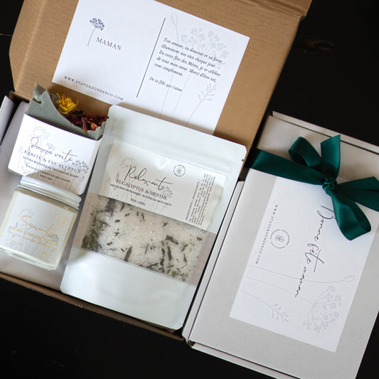 Coffret cadeau fête des mères comprenant une bougie, un savon botanique et des sels de bain, présenté avec une touche naturelle et élégante.
